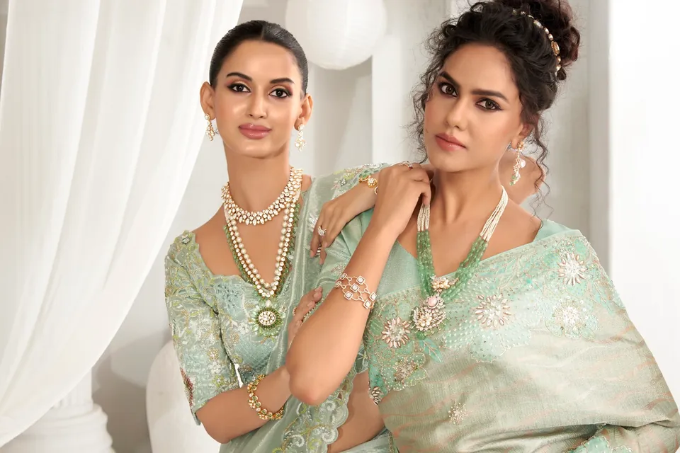 Two models in mint and sage silk wearing layered strands and long necklaces