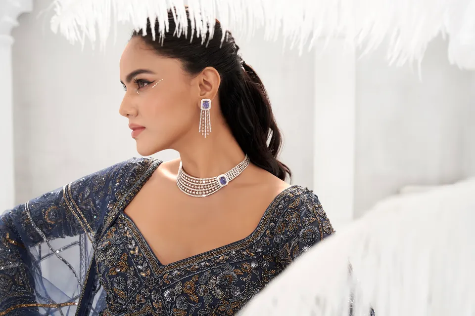 Profile in navy showing a diamond choker with a blue centre stone and tassel earrings
