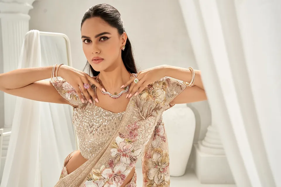Model with arms spread across the shoulders, wearing rose-gold bangles and a necklace