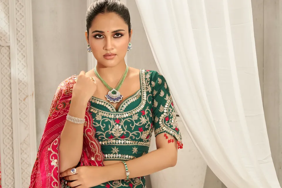 Model with a hand on the chest, showing a bracelet, rings and a long necklace