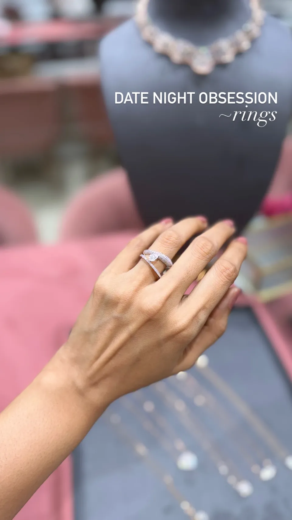 A hand wearing a crossover diamond ring at the showroom counter